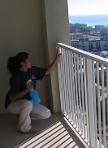 girl cleaning the dust off of the balcony railings